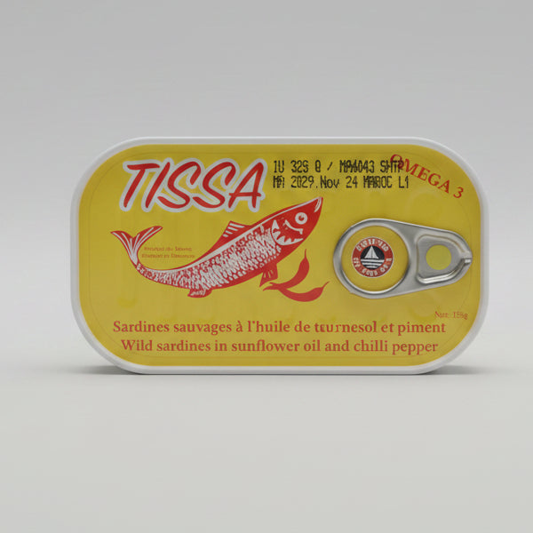 A can of Tissa Omega 3 wild sardines with a bright yellow label, resting on a dark surface with a blurred kitchen background.